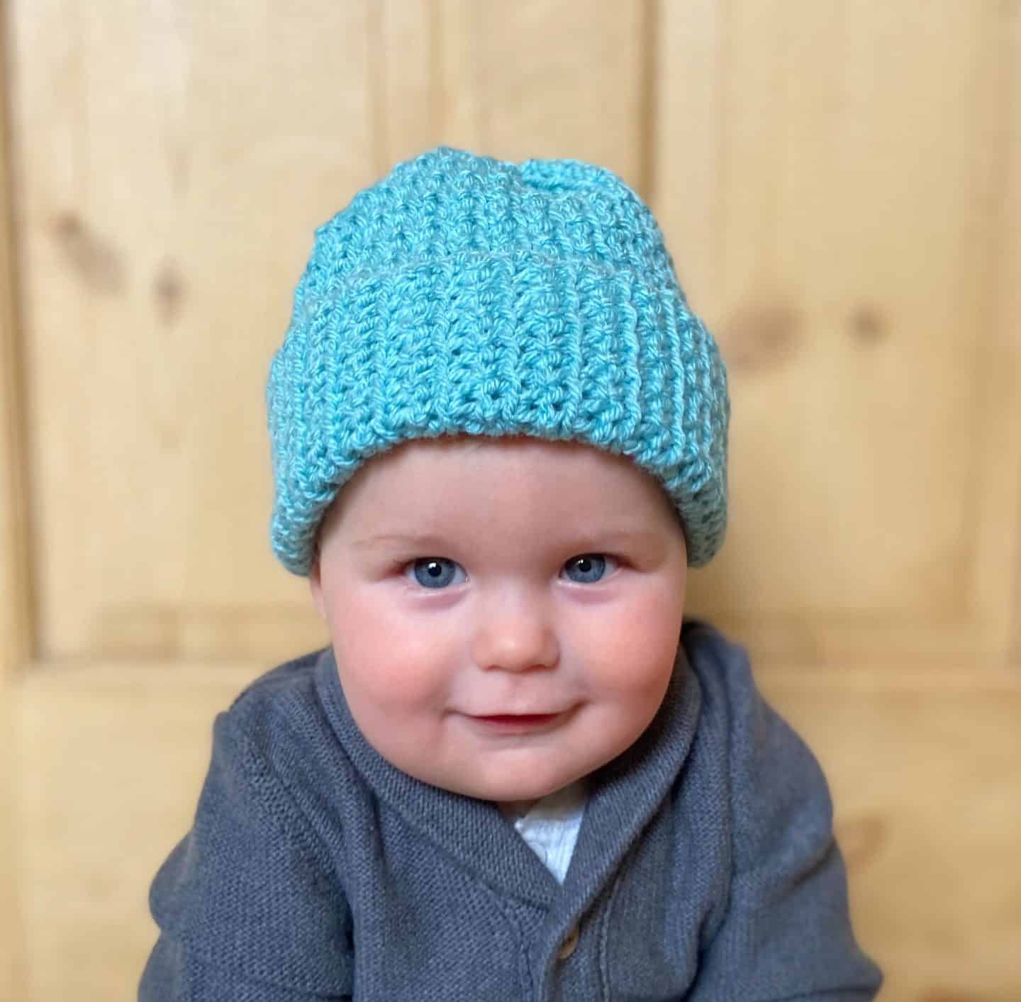 baby wearing blue crochet winter beanie hat