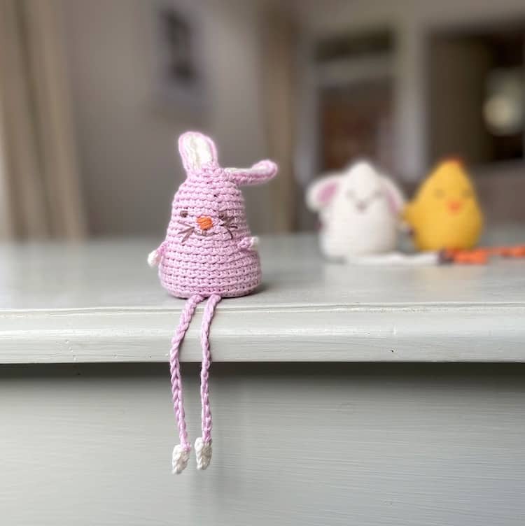 amigurumi crochet bunny sitting on edge of shelf