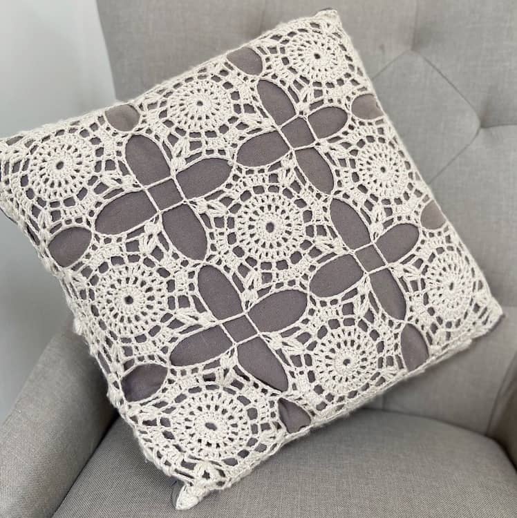 white crochet lace square cushion on grey chair