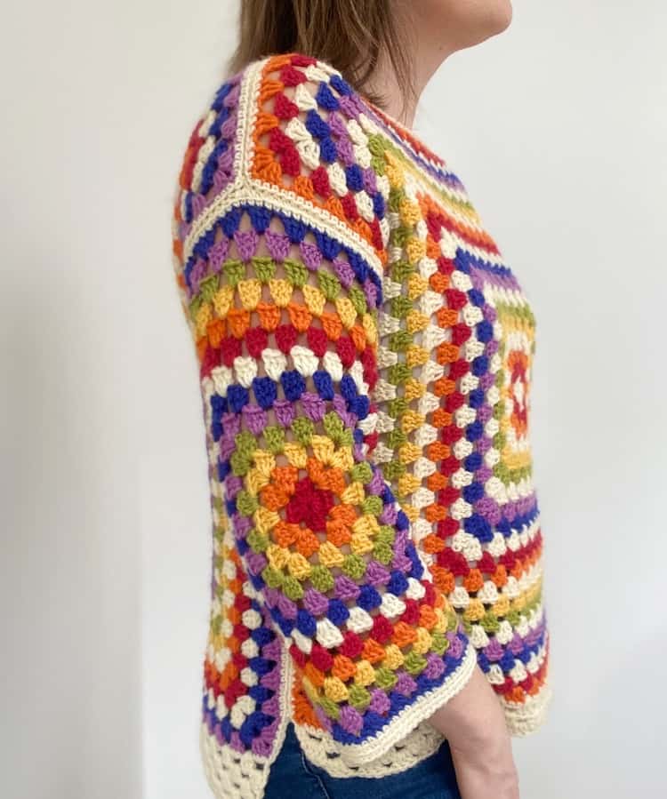 Side view of person wearing rainbow crochet sweater.