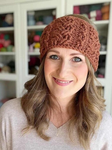 Woman wearing crochet cable headband pattern.