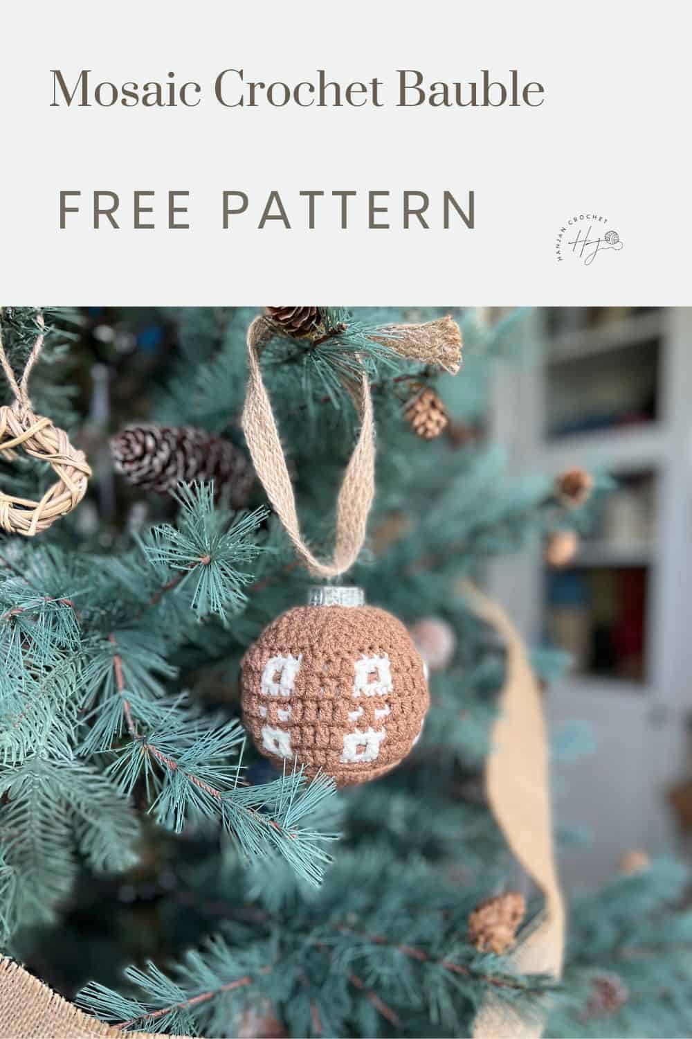 A handmade brown and white crocheted bauble ornament with charming spots hangs on a Christmas tree. Text at the top reads, "Mosaic Crochet Bauble FREE PATTERN.