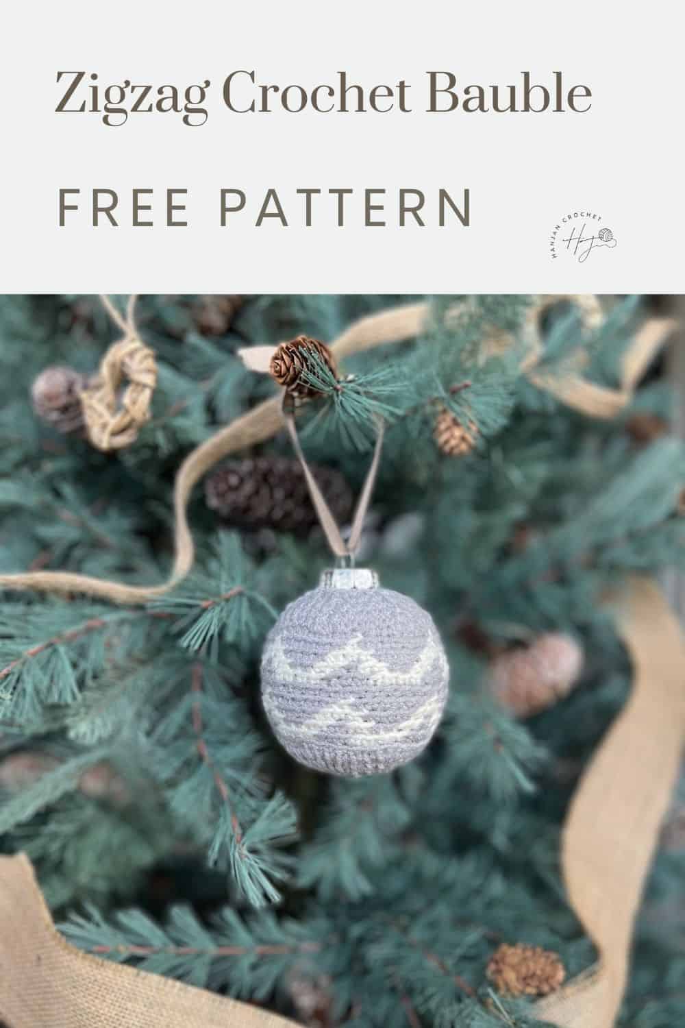 A gray and white zigzag-patterned crochet bauble hangs on a pine tree with a caption above it reading "Zigzag Crochet Bauble FREE PATTERN.