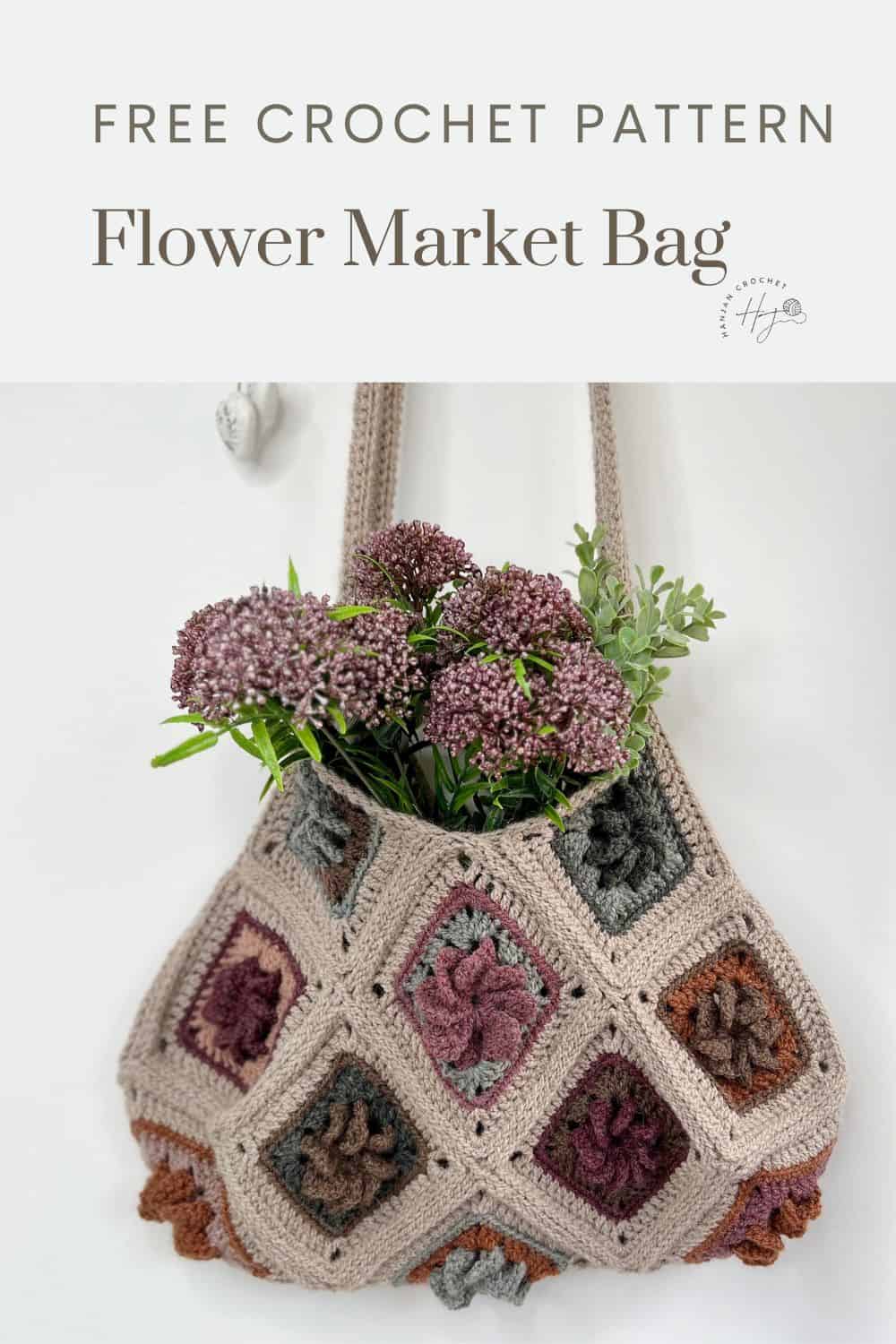 A crocheted Granny Square bag with multicolored floral square motifs is filled with purple and green flowers, hanging against a white background. Text above reads, "Free Crochet Pattern Flower Market Bag.