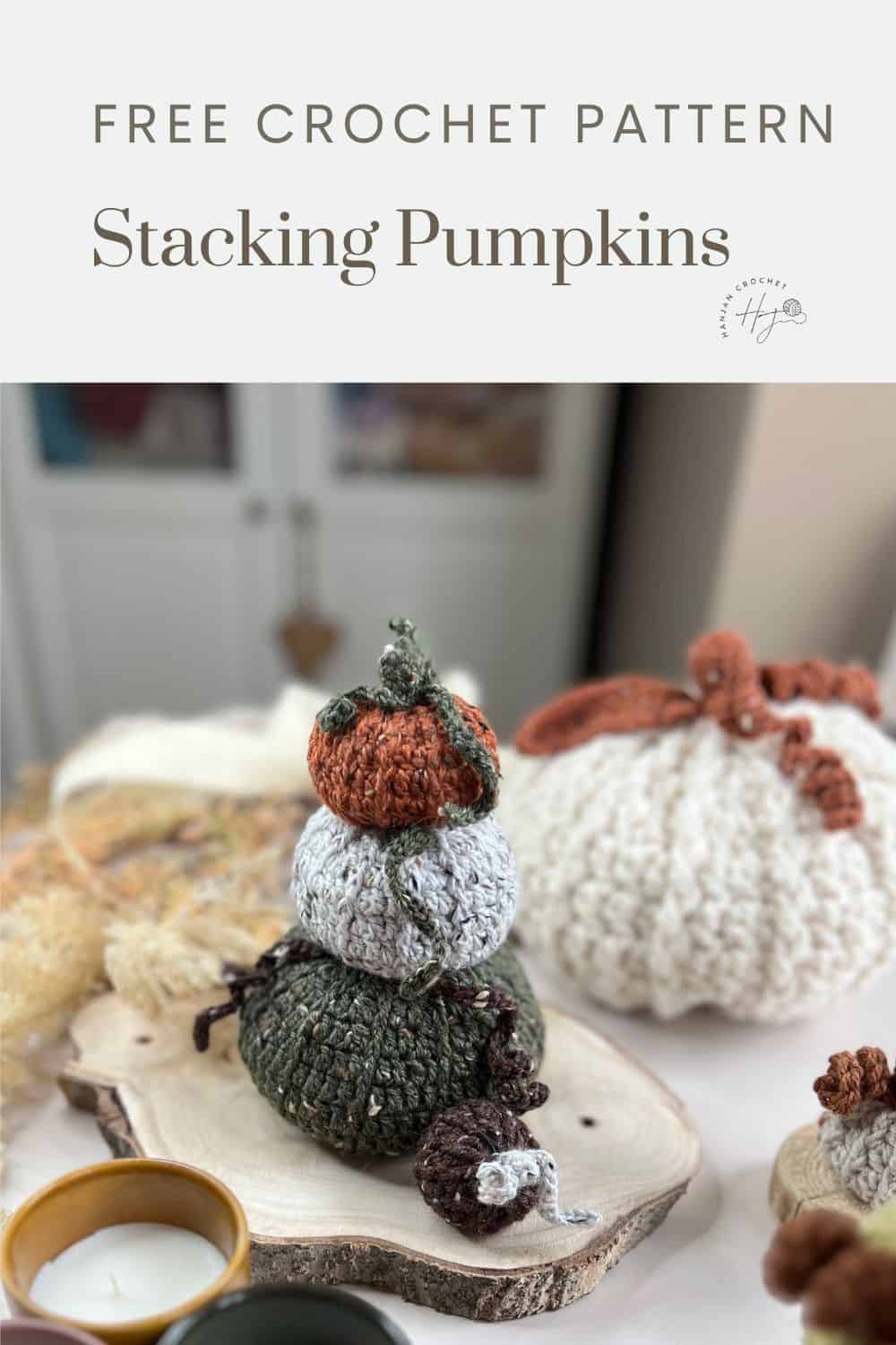         Free crochet pumpkins pattern for stacking pumpkins displayed on a wooden slice, with a candle and additional crochet pumpkins in the background.