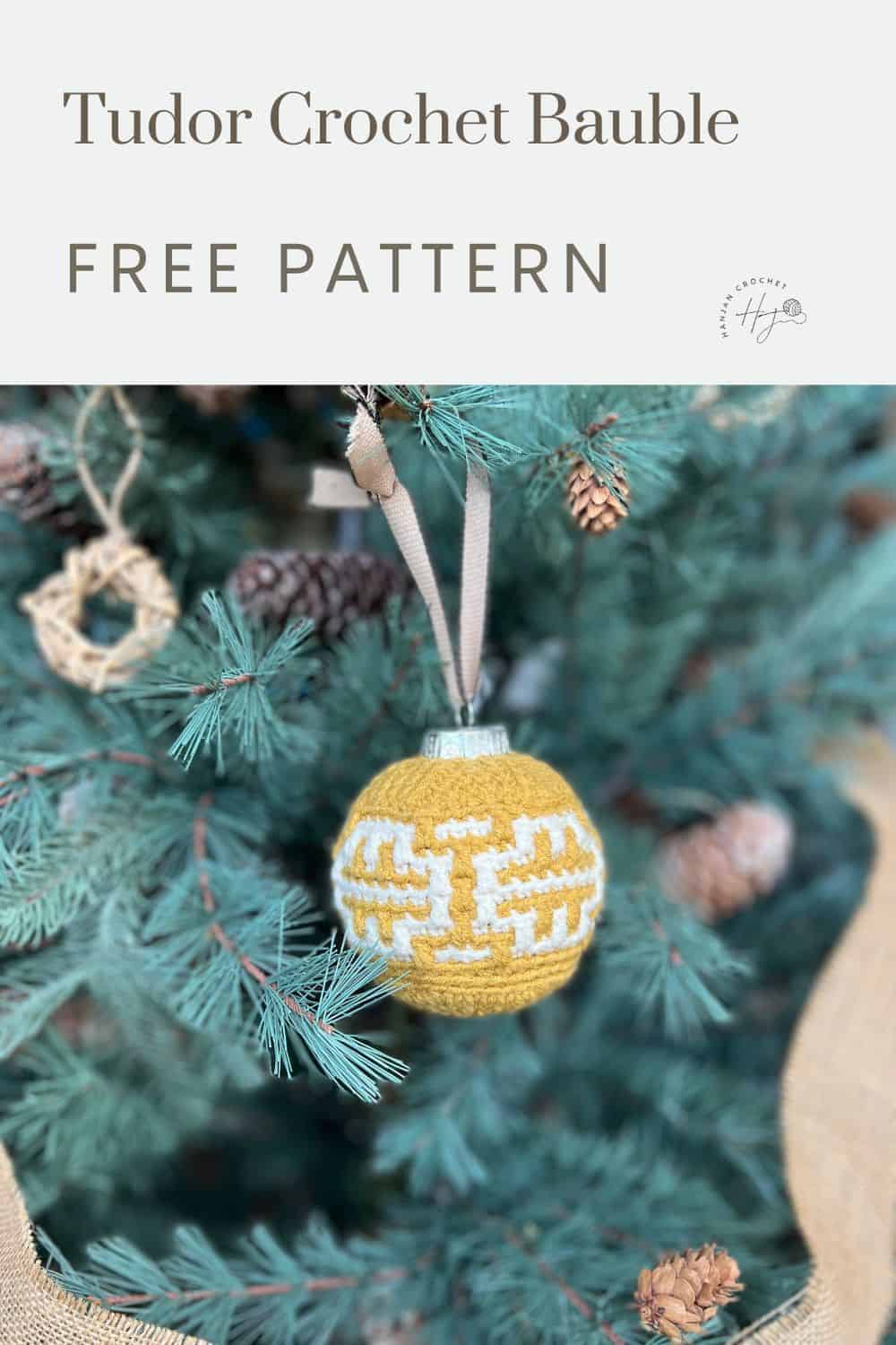 A yellow and white crocheted ornament hangs on a Christmas tree with pinecones and greenery. Text above reads, "Tudor Crochet Bauble FREE PATTERN." This easy mosaic crochet bauble adds a touch of handmade charm to your holiday decor.