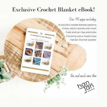 Tablet displaying a crochet eBook with colorful blanket patterns, surrounded by text detailing over 30 pages of crochet content, and a hanjan crochet logo on a wooden surface.