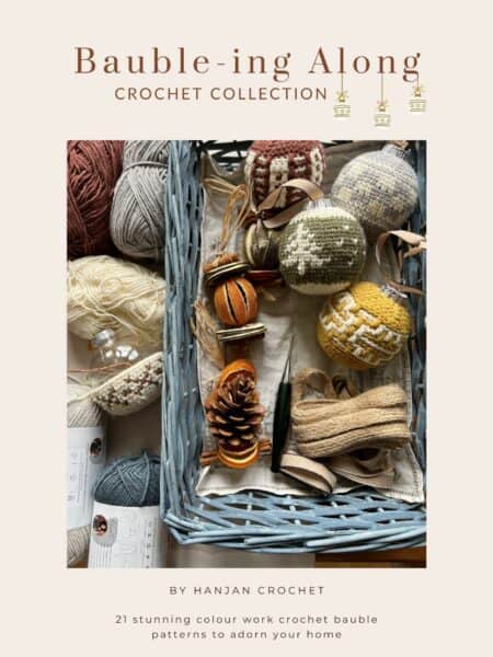 Crochet baubles and yarn balls displayed in a basket, accompanied by pine cones and crochet hooks, on a promotional material for a crochet collection.